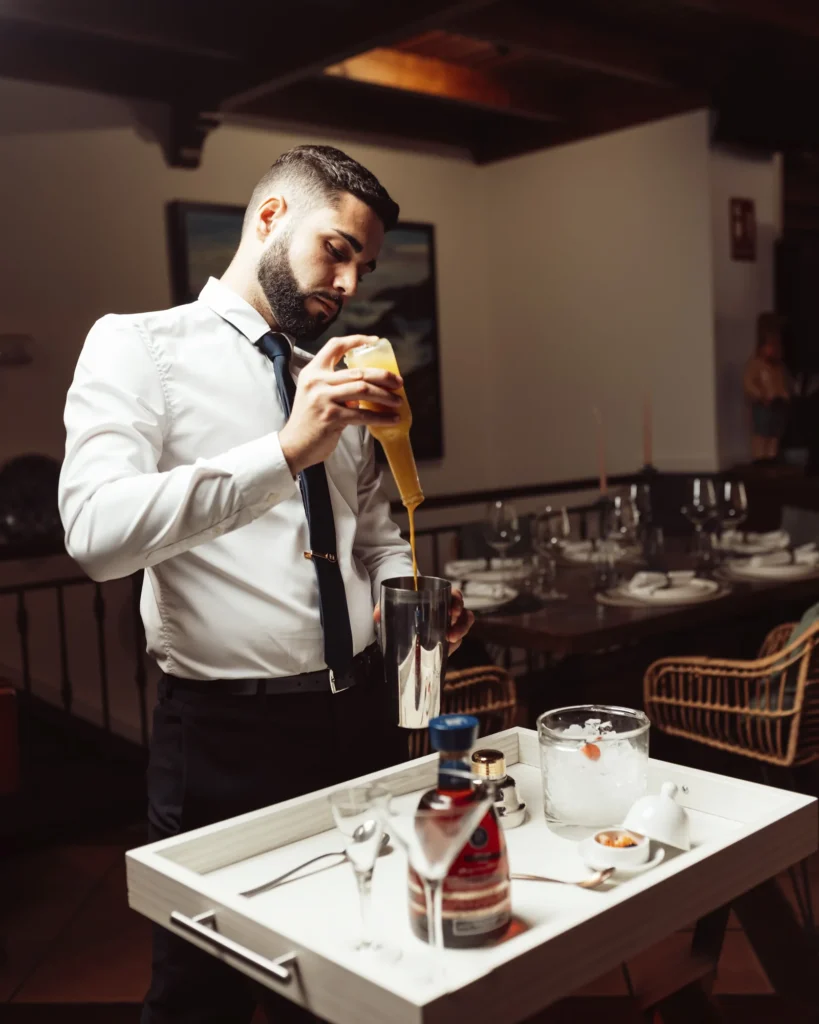 Un miembro del equipo prepara el servicio de vino en la sala del restaurante.